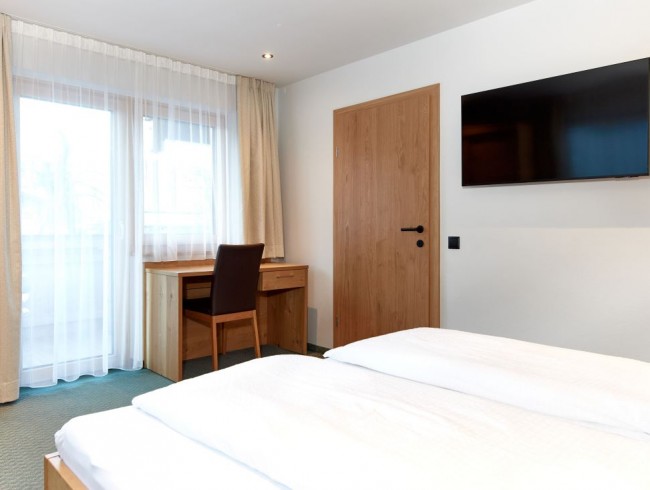 Schlafzimmer mit Doppelbett, Flat-TV und Balkon