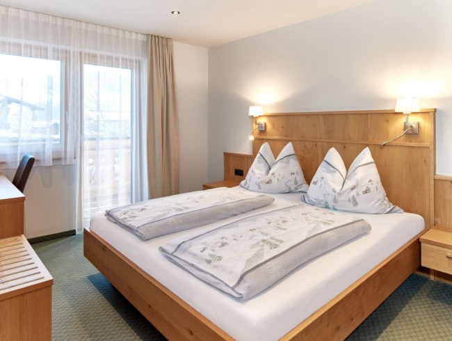 Schlafzimmer mit Doppelbett, Flat-TV und Balkon