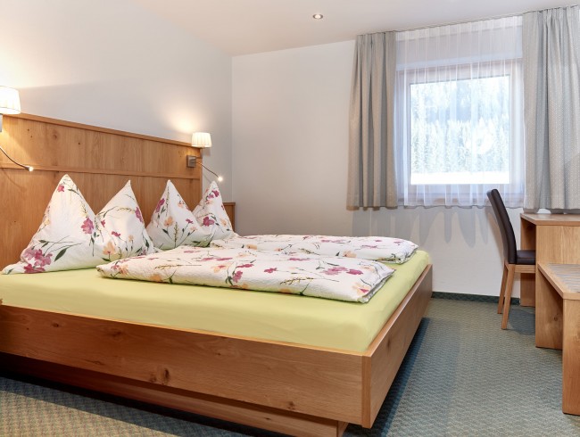 Schlafzimmer mit Doppelbett und TV