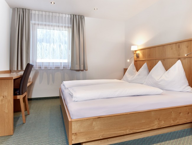 Schlafzimmer mit Doppelbett und TV