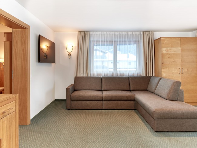 Wohnzimmer mit großer Couch und TV