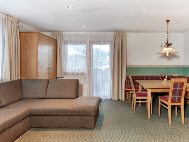 Wohnküche mit Ccouch und Esstisch und TV